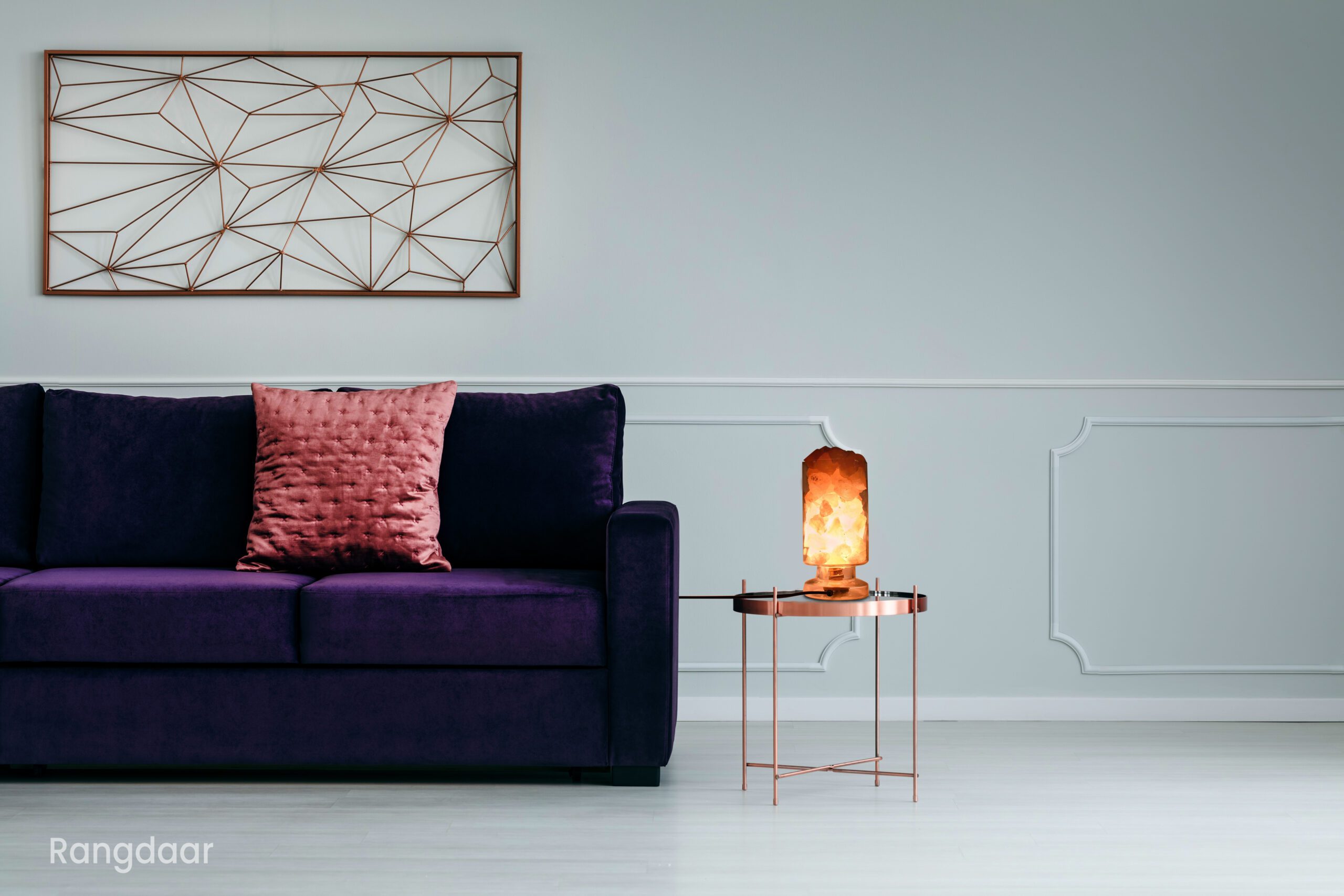 Ultra violet sofa and metal side table in empty living room interior